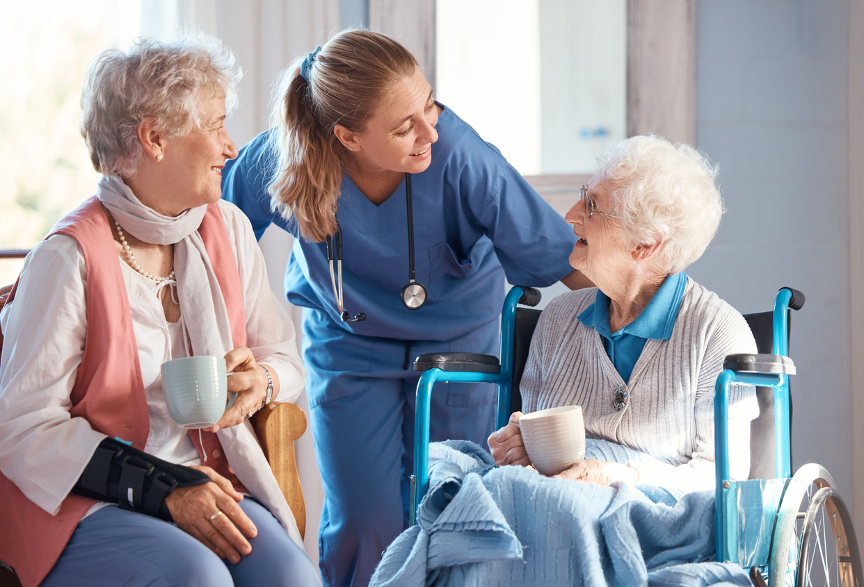 nursing-home-care-and-nurse-with-senior-women-doing-healthcare-checkup-examination-or-consultation-medical-conversation-and-elderly-woman-in-wheelchair-consulting-a-doctor-at-retirement-facility